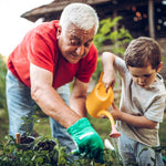 Man and child gardening together, with the child holding a yellow watering can.