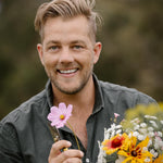 A man named Ashley James is holding a bouquet of fresh-cut flowers