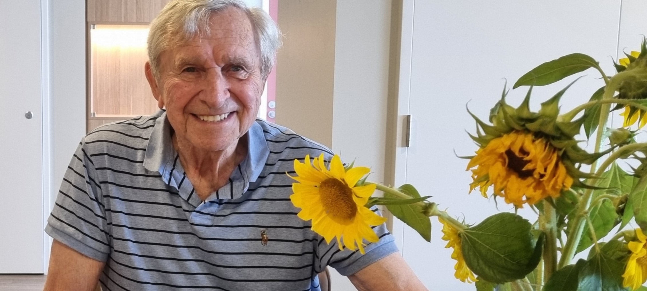 maurice kennedy with sunflowers in a vase