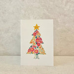 Card with a floral Christmas tree design on a textured beige background