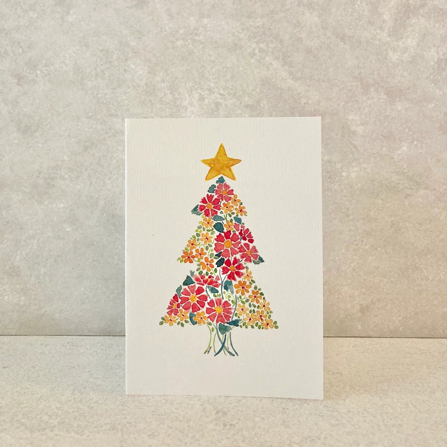 Card with a floral Christmas tree design on a textured beige background